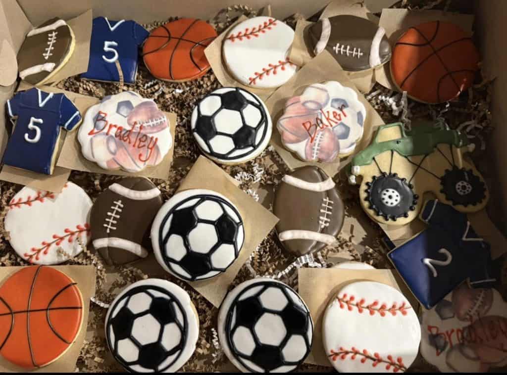 Assorted sports-themed cookies including soccer, football, basketball, and baseball.