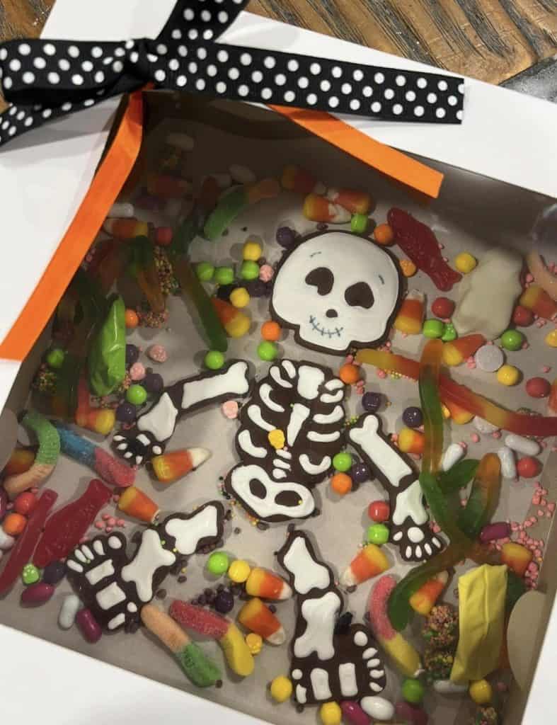 Halloween candy box with skeleton design and colorful candies from Smutz Girls Bakery.