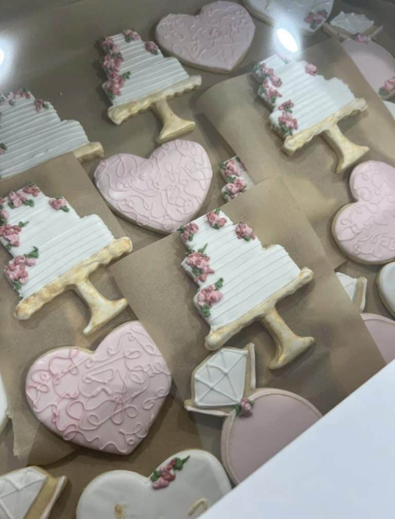 Decorated cookies from Smutz Girls Bakery with pink and white icing and floral details.