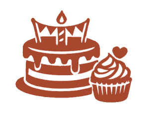 Birthday cake with candles and a cupcake with heart decoration at Smutz Girls Bakery.