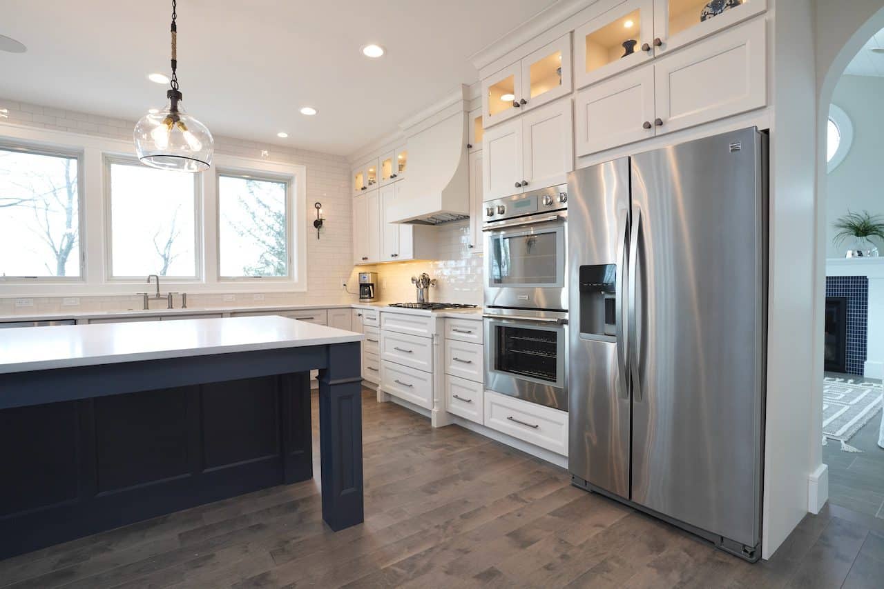 Contemporary kitchen with white cabinets, stainless steel appliances, and a large island.