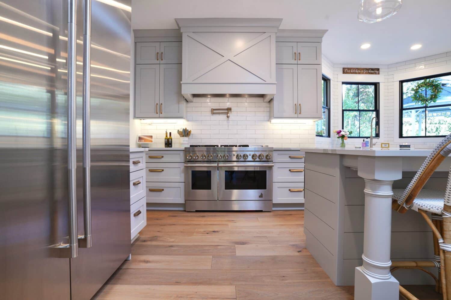 Bright modern kitchen with white cabinets, stainless steel appliances, and a large island.