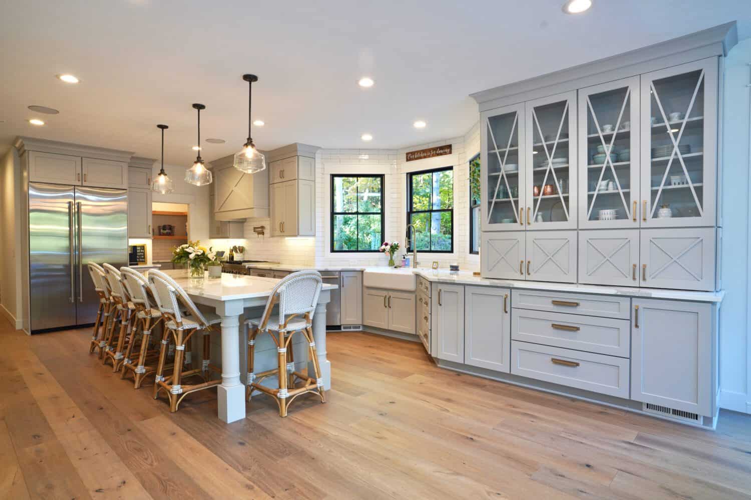 Spacious modern kitchen with light blue cabinets, island, and stainless steel appliances.
