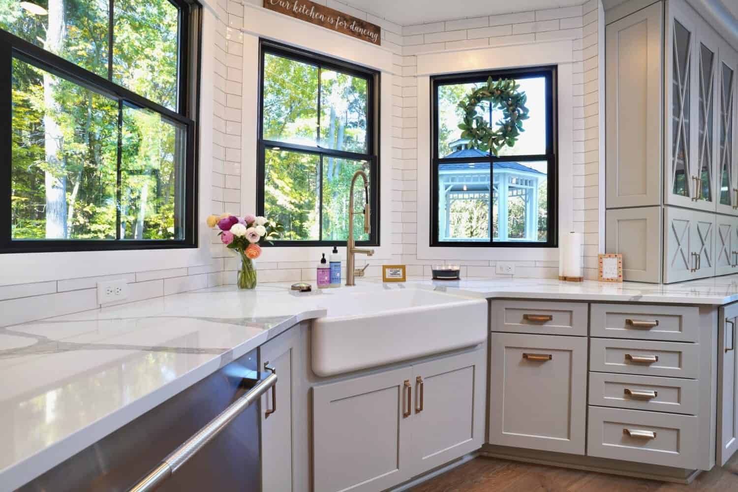 Bright white kitchen with large windows and elegant cabinetry.