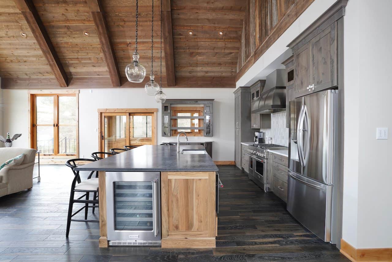 Contemporary kitchen with wooden ceiling, stainless steel appliances, and island counter.