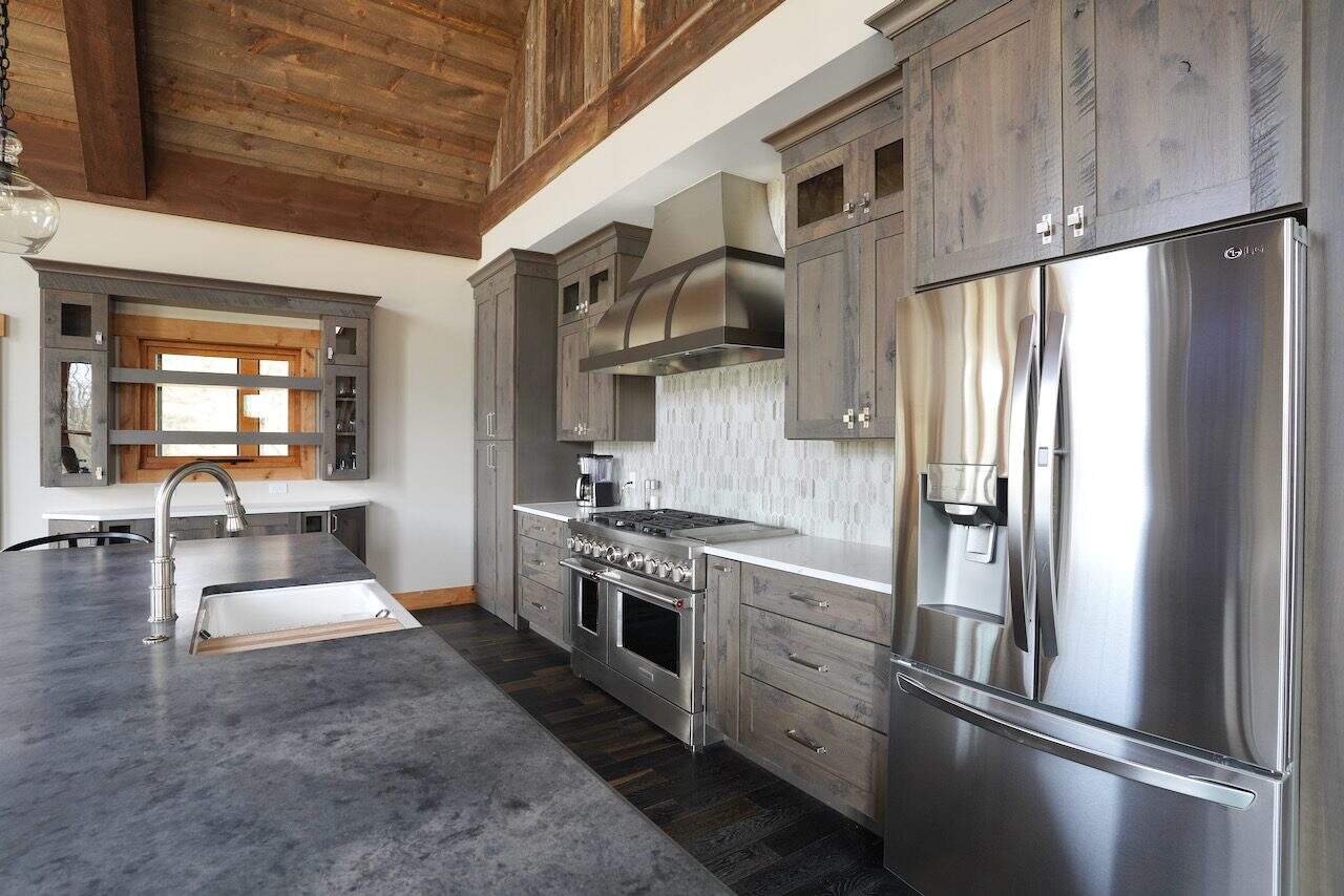 Contemporary kitchen with gray wooden cabinets and stainless steel appliances.