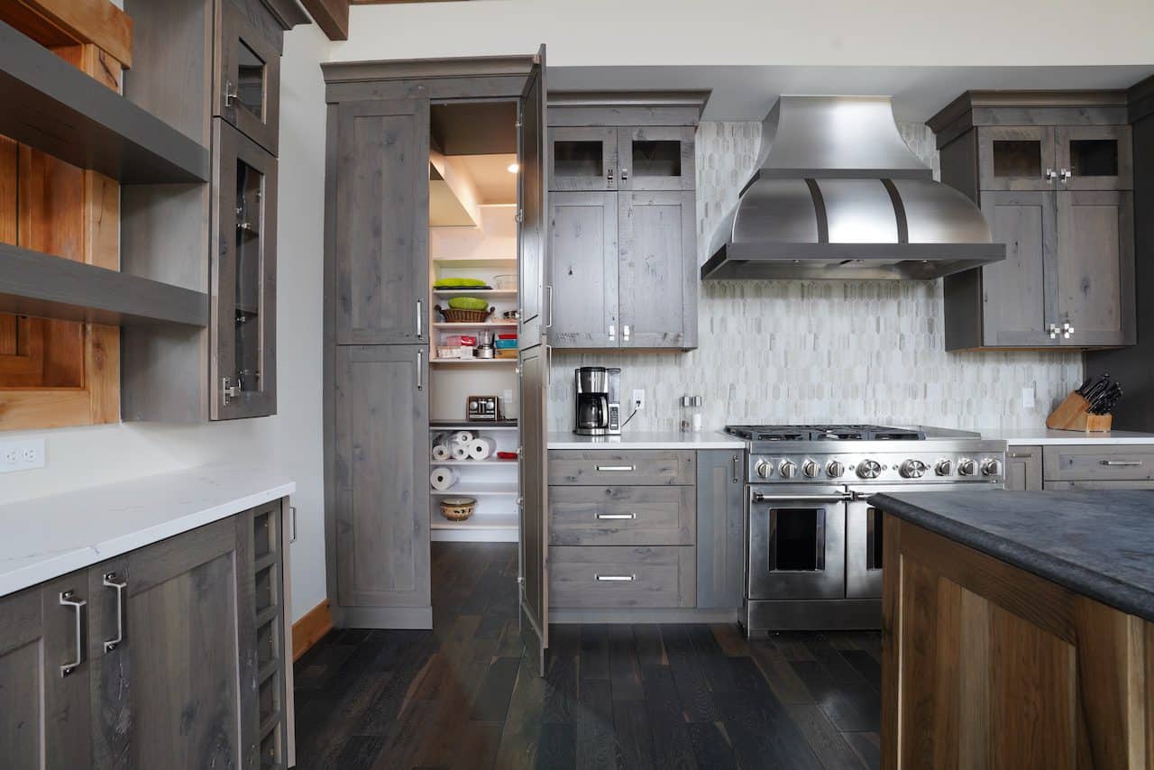 Contemporary gray kitchen with stainless steel appliances and open shelving.