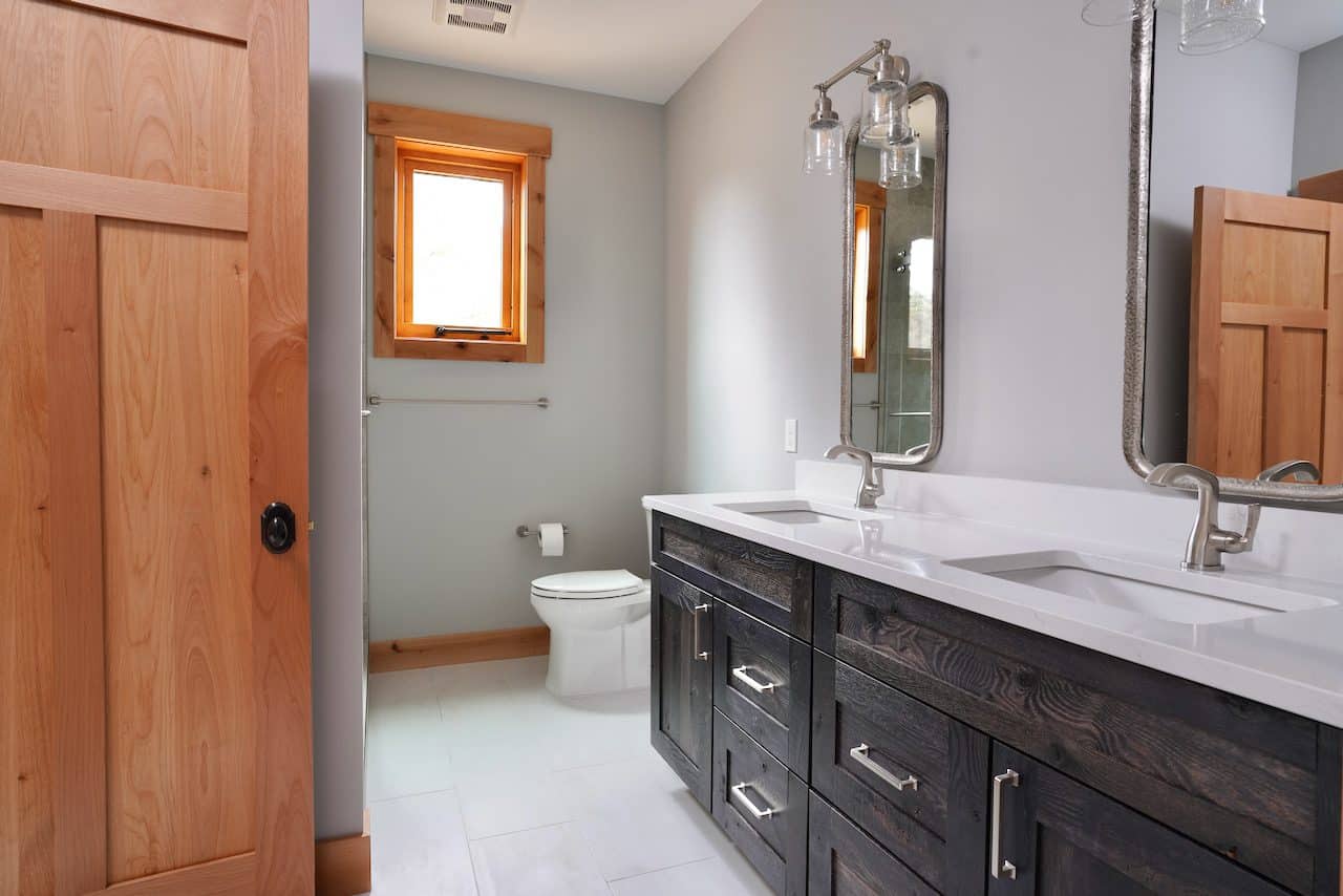 Contemporary bathroom with double sink vanity, mirror, and wooden accents.