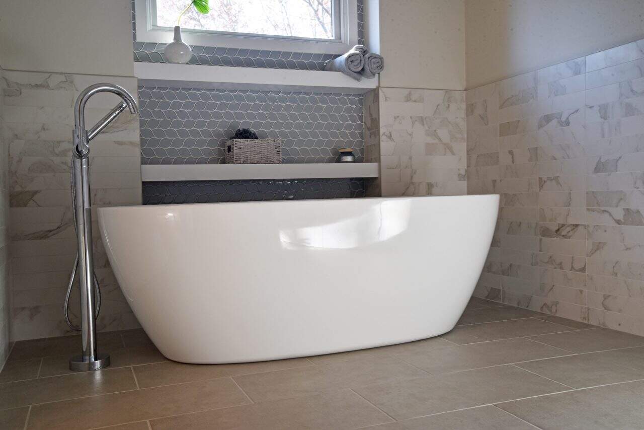 White freestanding bathtub in a contemporary bathroom with natural light.