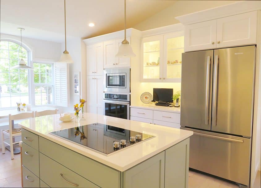 Bright modern kitchen with white cabinets and stainless steel appliances.