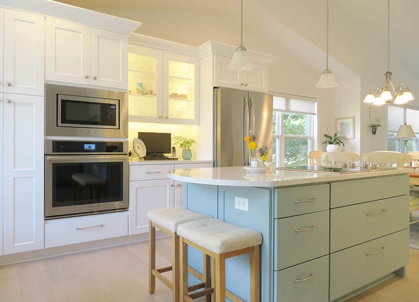 Bright modern kitchen with white cabinets, stainless steel appliances, and a central island.