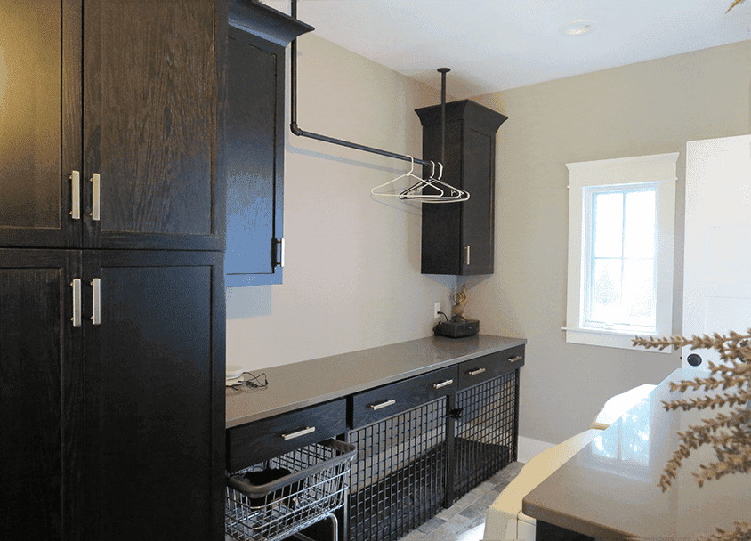Modern closet with black cabinets, hanging rod, and storage baskets.