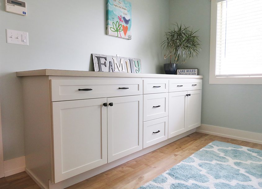 Elegant white sideboard with decor and plant in living room.