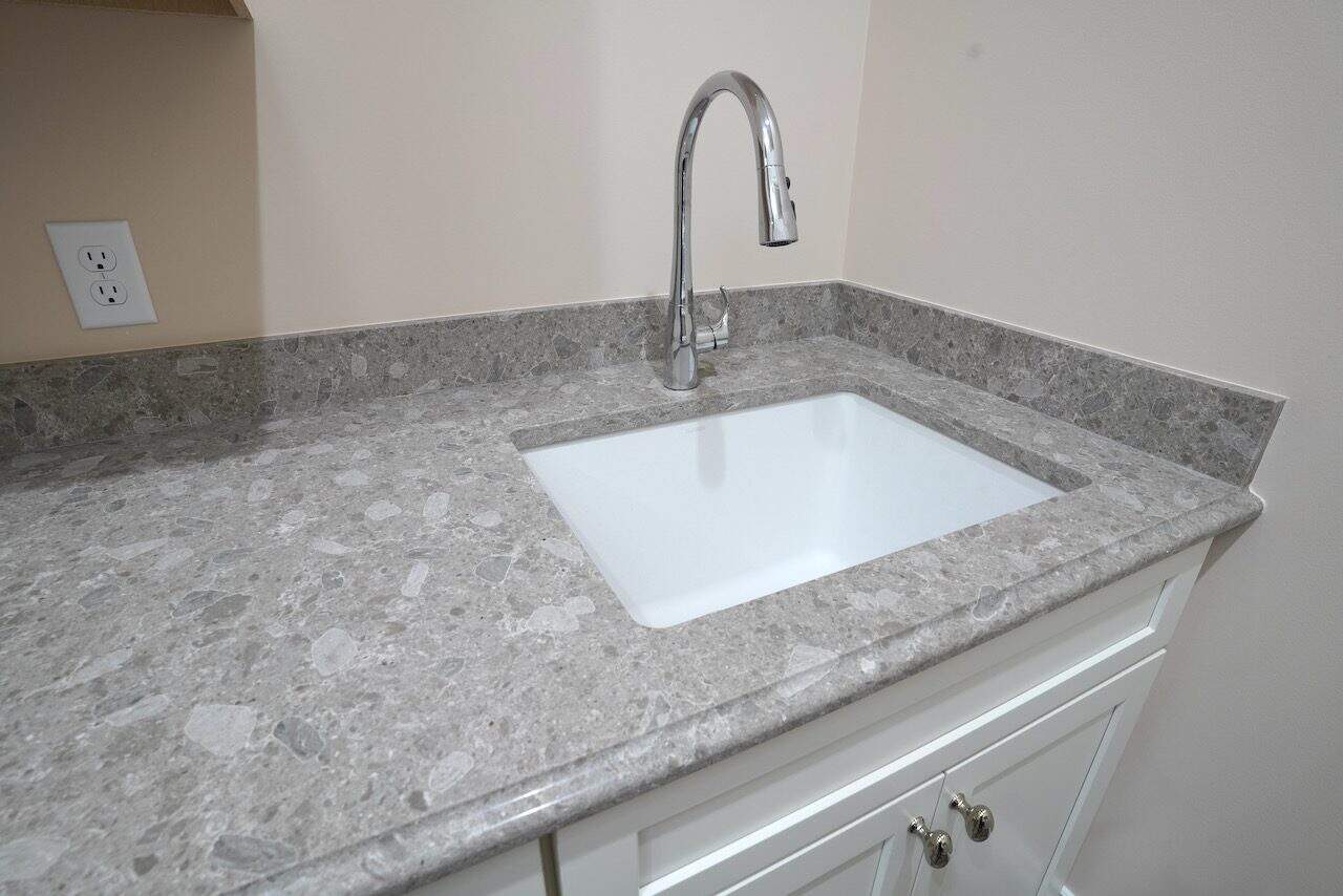 Modern kitchen sink with granite countertop and chrome faucet.
