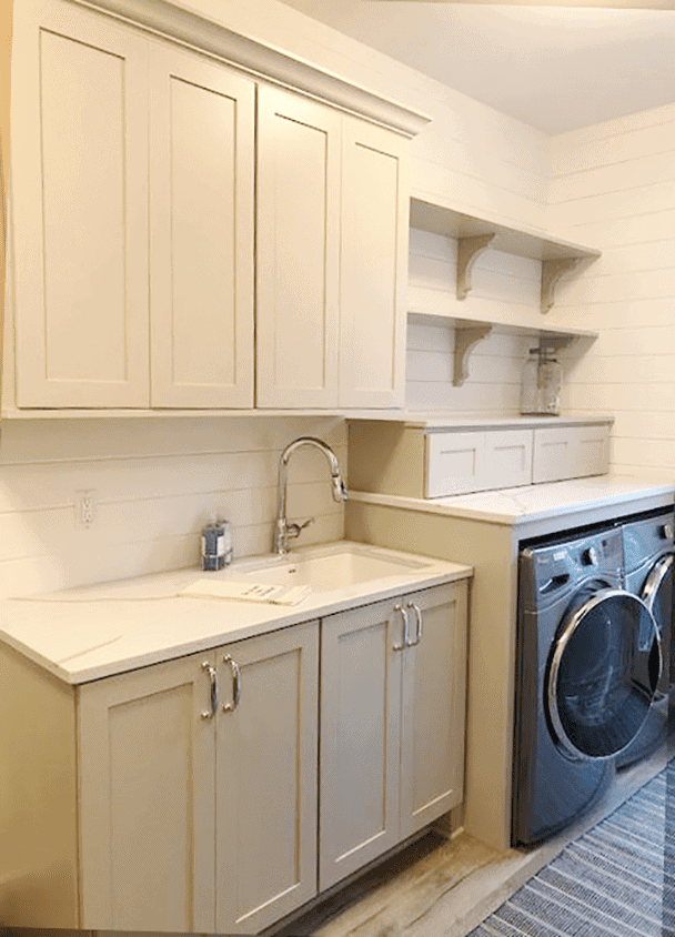 Laundry room with white cabinets and front-loading washer and dryer.