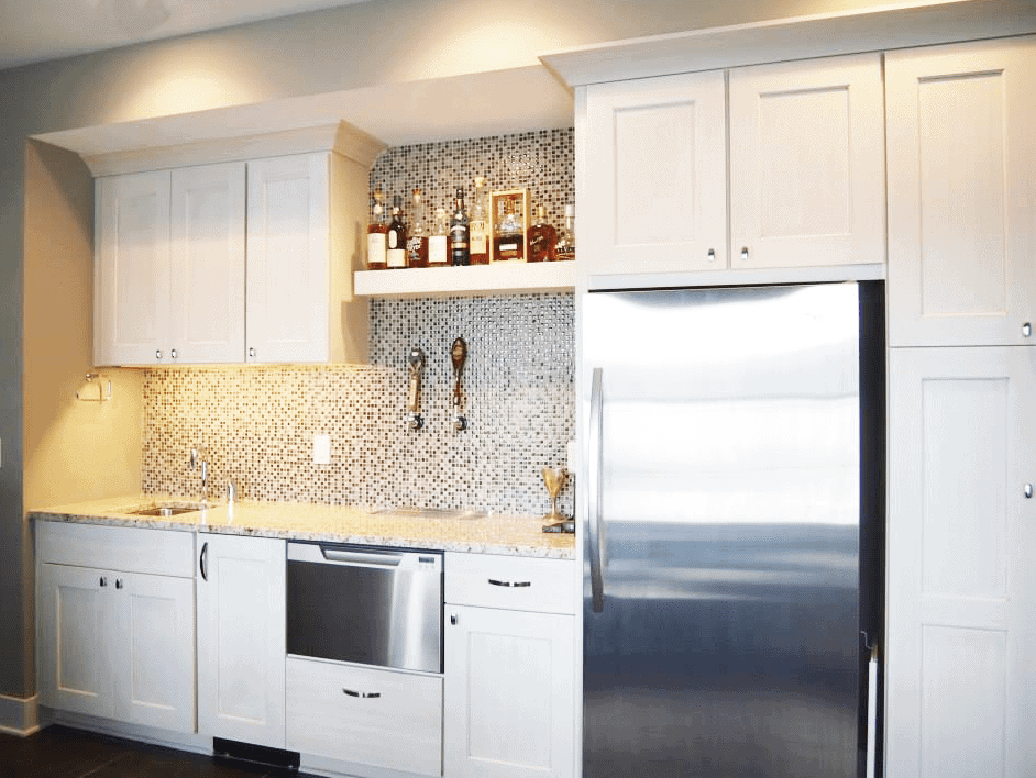 Contemporary kitchen with white cabinetry, stainless steel refrigerator, and mosaic backsplash.