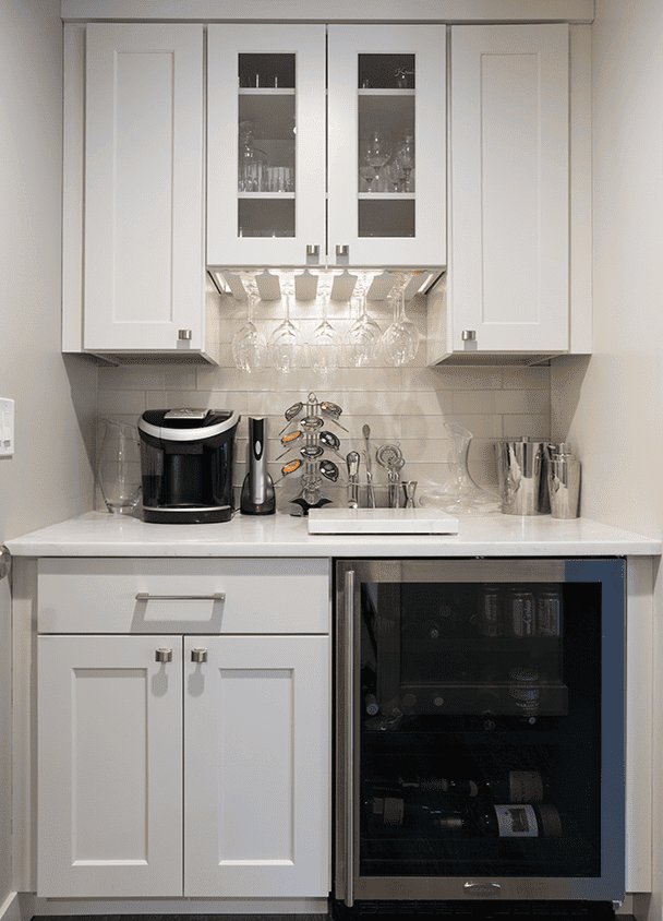 Contemporary kitchen with white cabinets, wine cooler, and glass-front upper cabinets.