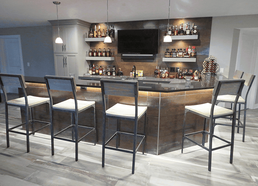 Modern home bar with seating and liquor display by All Season Innovations.