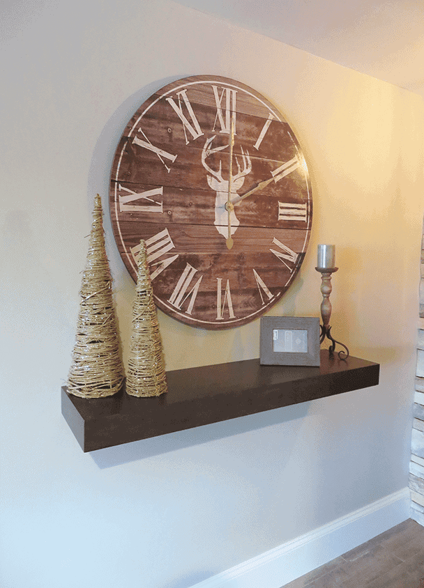 Large round wooden wall clock with Roman numerals and deer design.