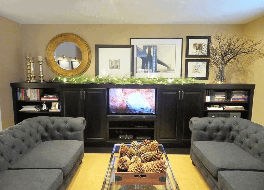 Living room with black entertainment center, two gray sofas, and decorative wall art.