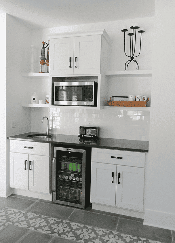 Contemporary kitchen with white cabinets, microwave, and wine cooler.