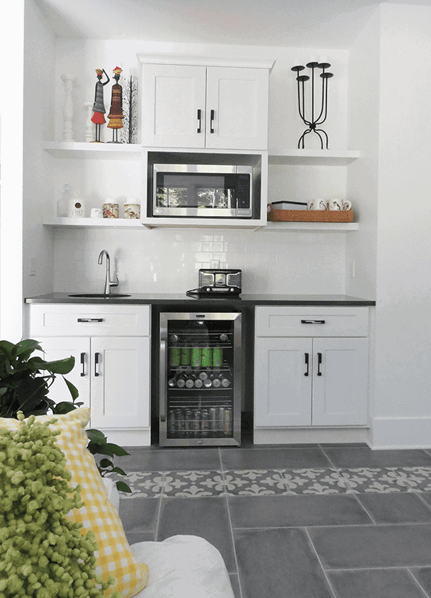 Contemporary kitchen with white cabinets, microwave, and wine cooler.