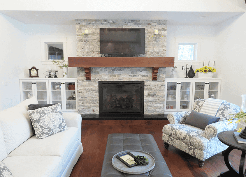 Living room with stone fireplace, flat-screen TV, and cozy seating area.