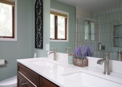 Contemporary bathroom with double sink vanity, large mirror, and glass shower enclosure.