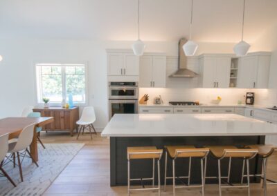 Contemporary kitchen with white cabinets and island, bright and spacious interior.