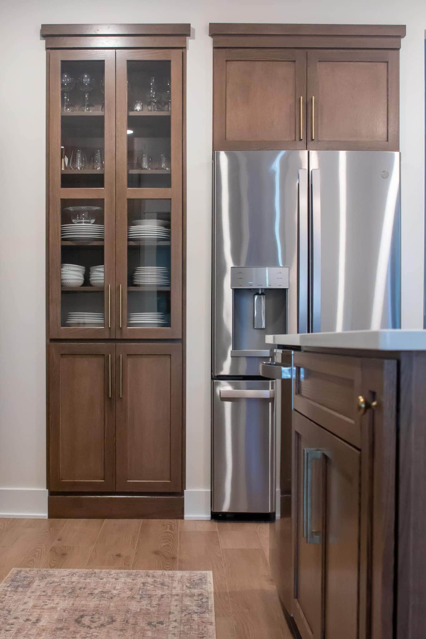 Kitchen with wooden cabinets, stainless steel refrigerator, and island.