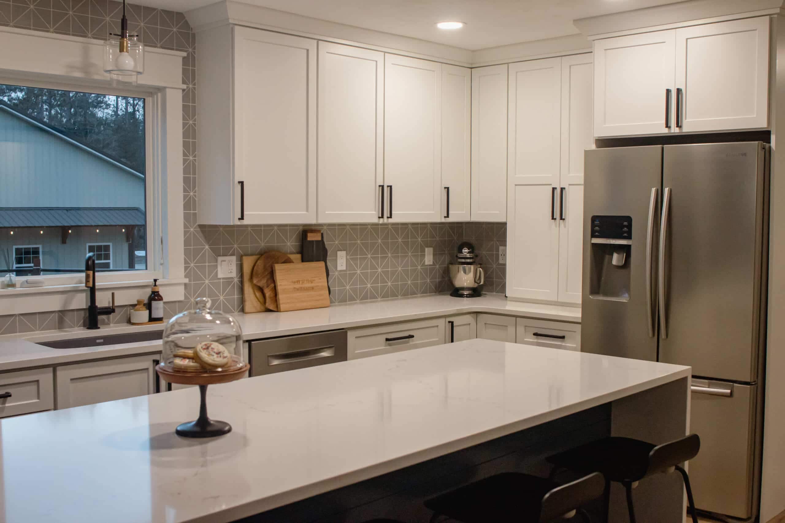 Contemporary kitchen with white cabinets, stainless steel appliances, and a large island.