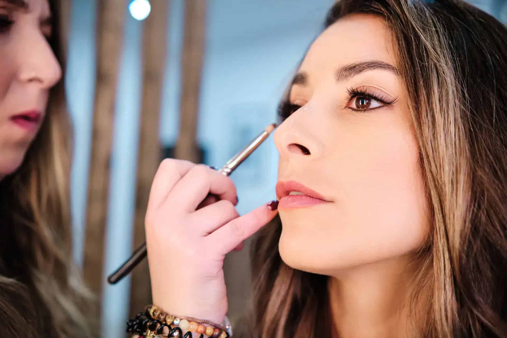 Makeup artist applying makeup to a woman's face at Beauty Bar & Spa.