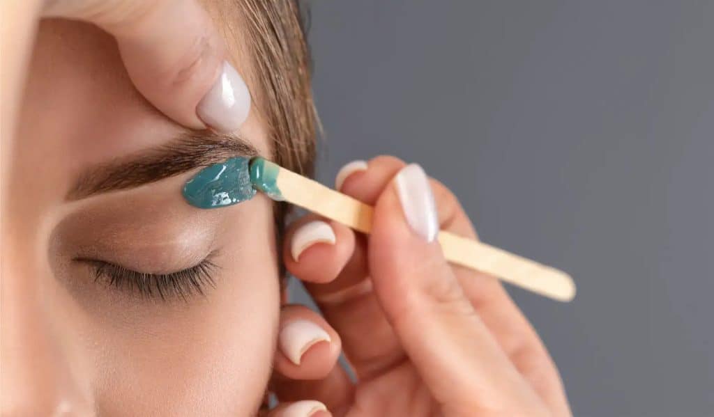 Close-up of eyebrow waxing process at The Beauty Bar & Spa.