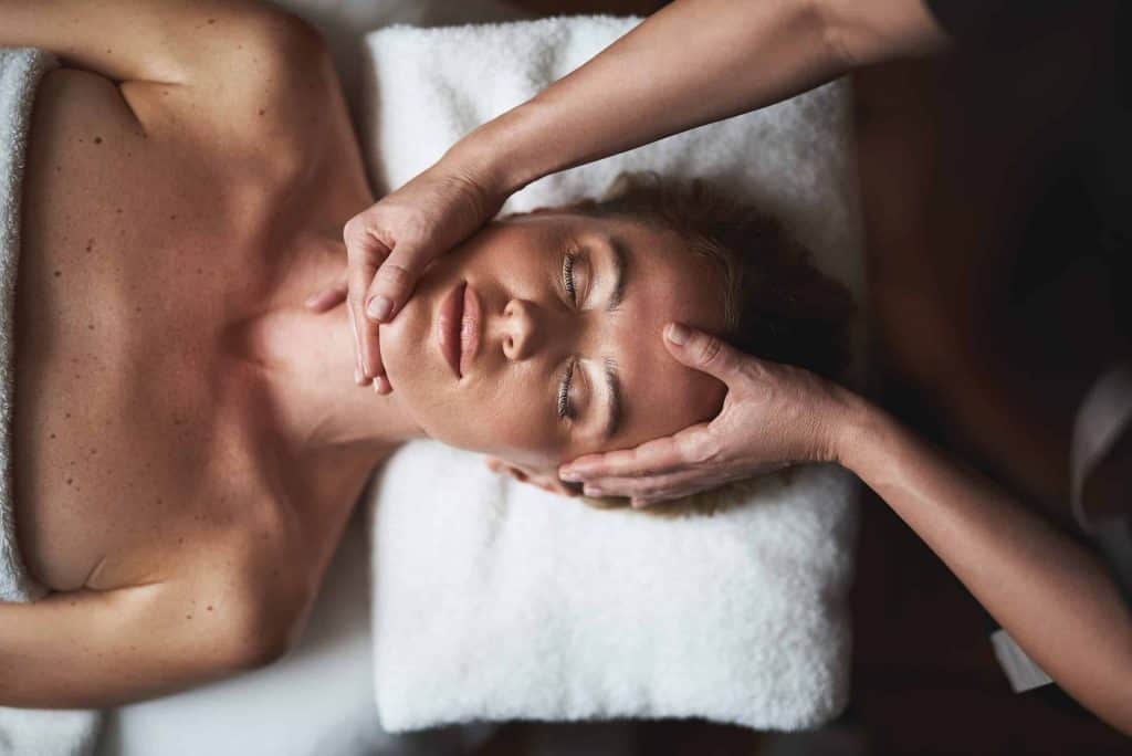 Woman receiving a facial massage at Beauty Bar & Spa for relaxation and skincare.