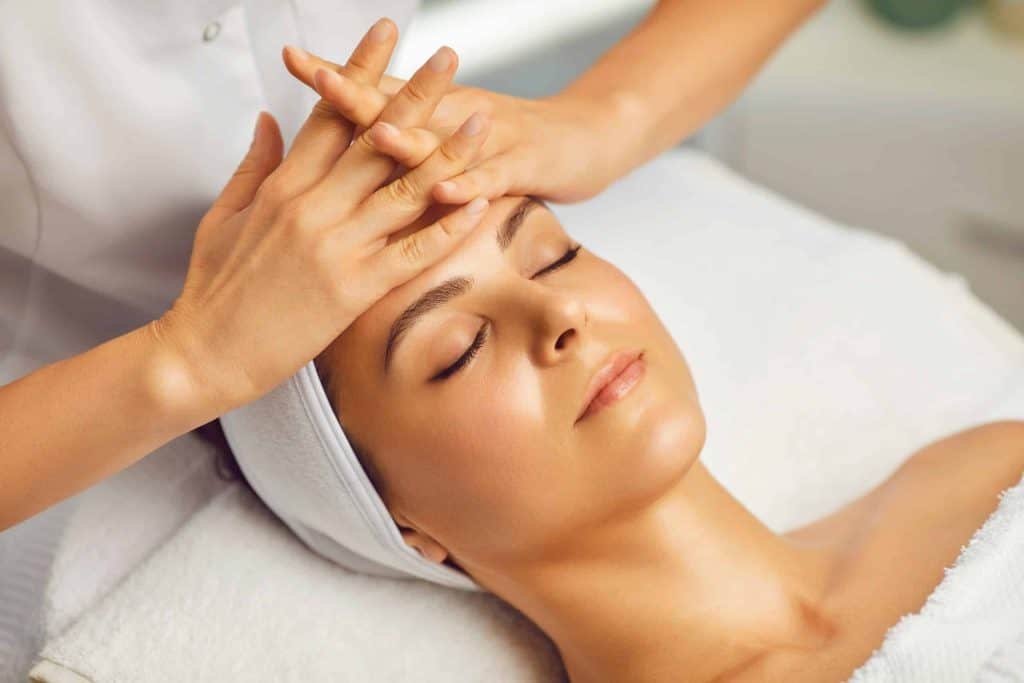 Woman receiving a facial massage at a spa for relaxation and skincare.