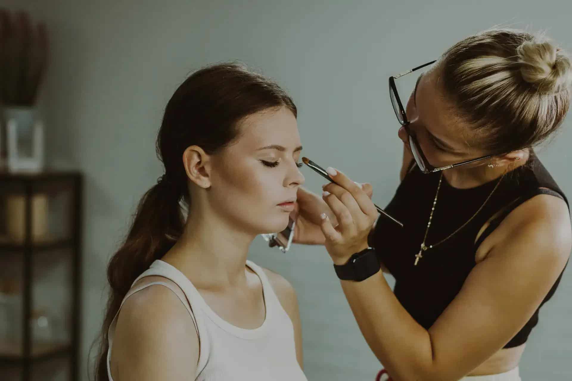 Bridal makeup artist applying makeup to a bride for wedding day.