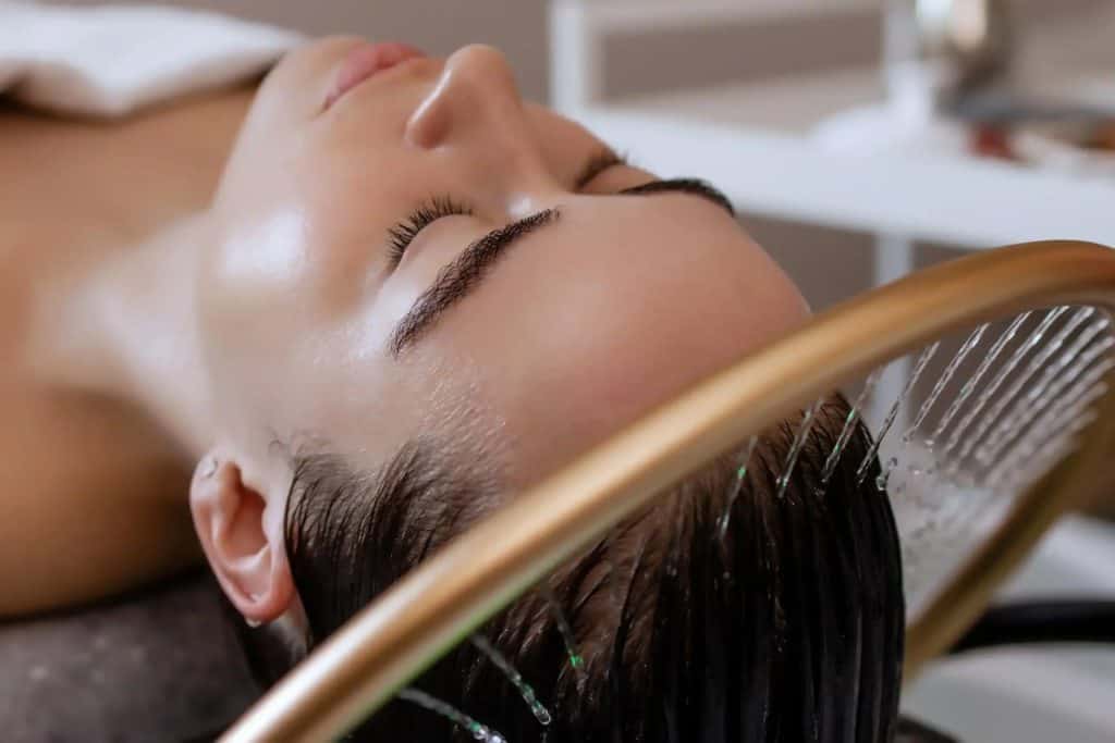Woman receiving Japanese head spa with relaxing hair wash and massage.
