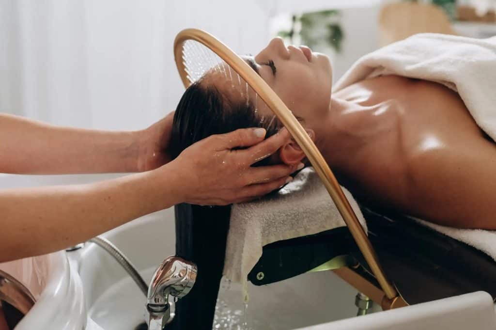 Woman receiving Japanese head spa treatment with relaxing massage and hair wash.