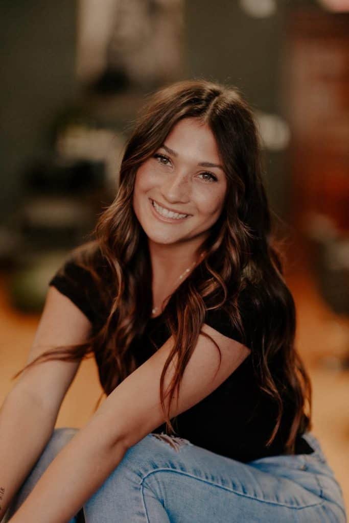 Smiling woman with long brown hair at Beauty Bar & Spa.