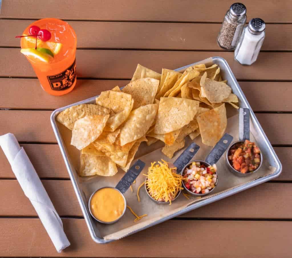 Chips with salsa, cheese, and dip on a metal tray at The Deck.