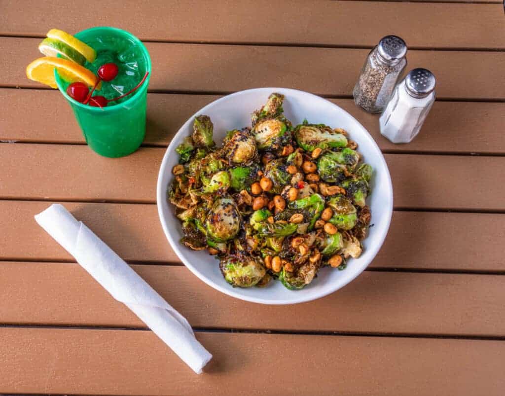 Crispy Thai Brussels sprouts with chickpeas on a white plate.