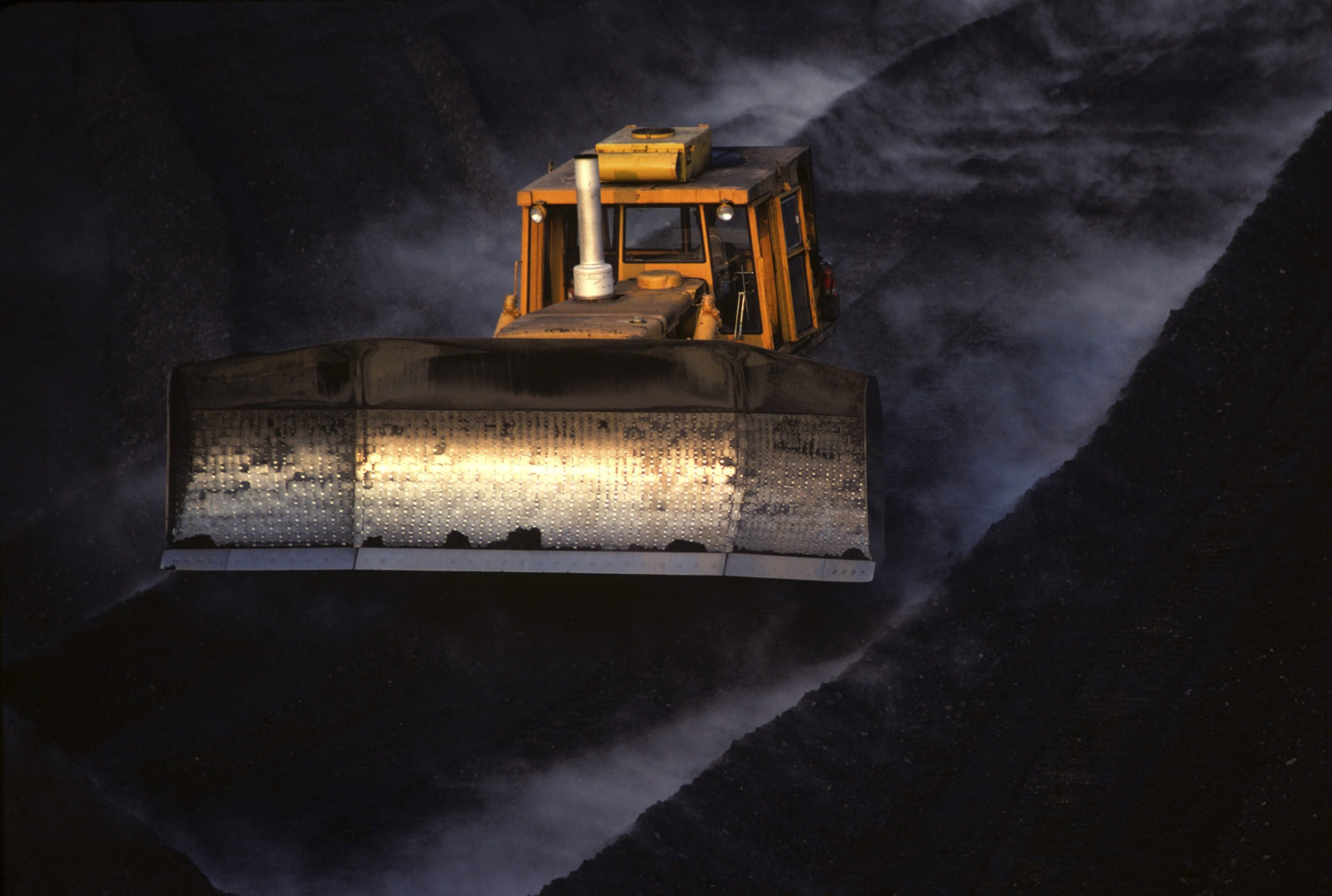 Moving coal with bulldozer for transport by train.