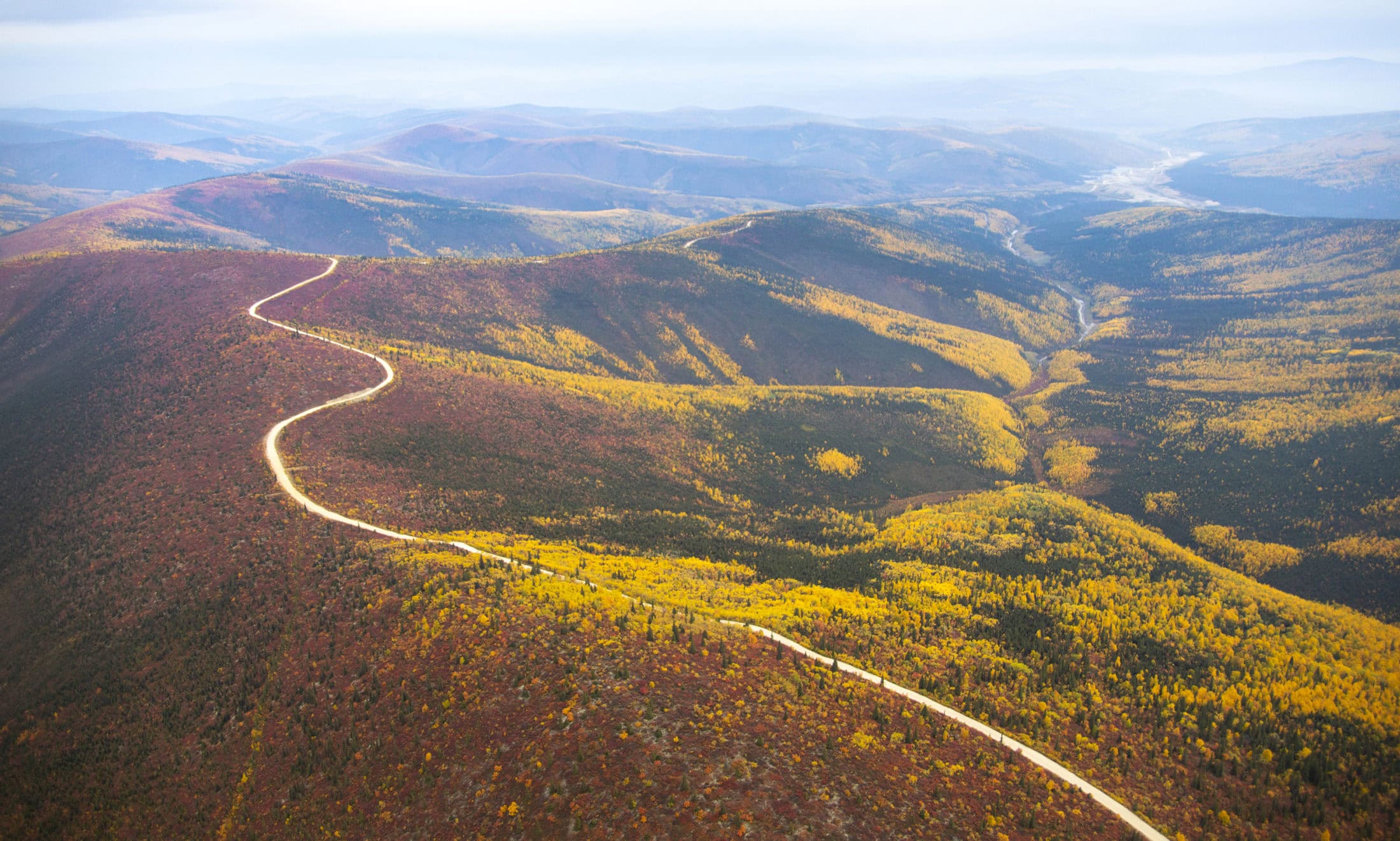 A road snakes along a ridgeline near Dawson City, Yukon.