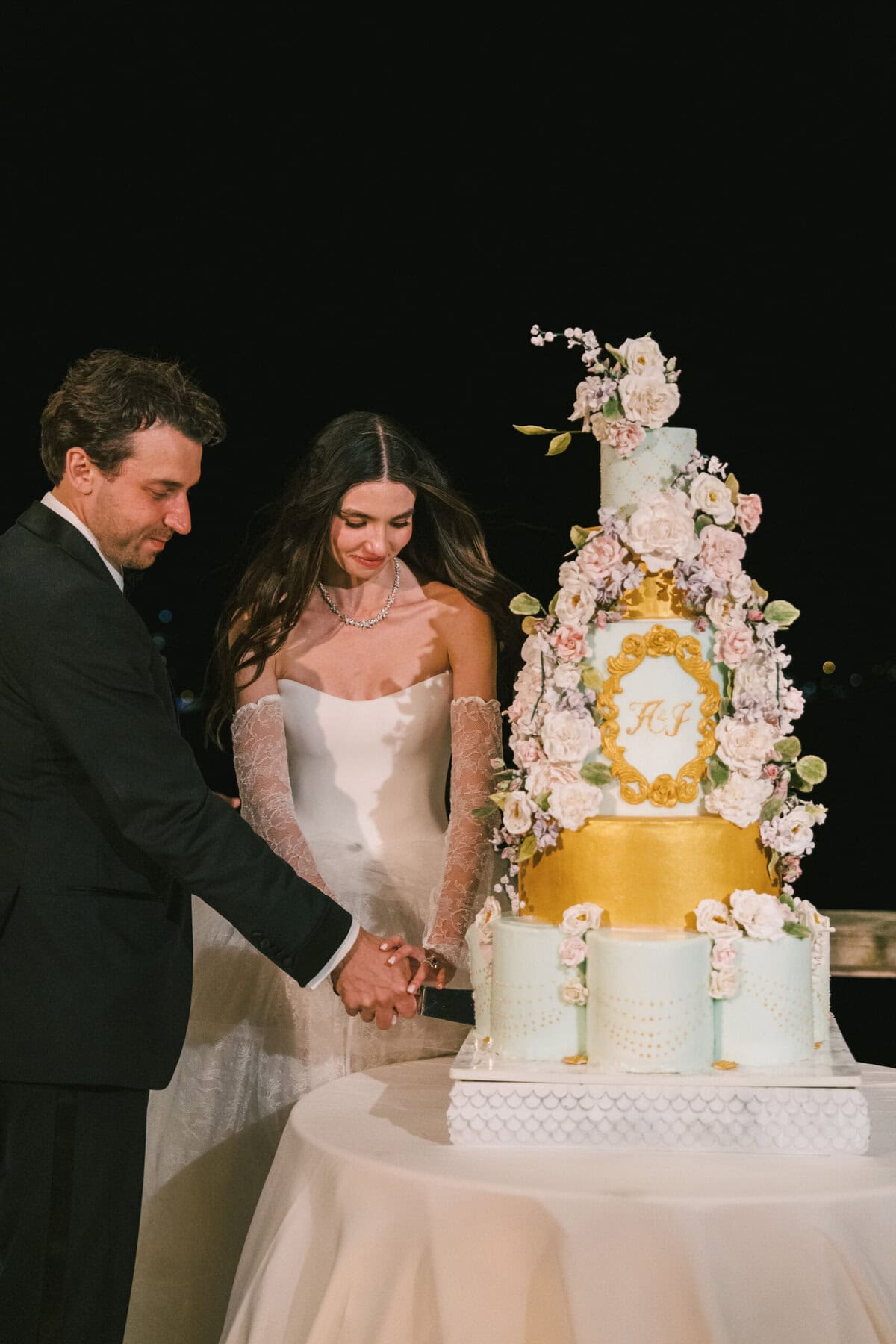 Bride and groom cutting their custom luxury wedding cake at Villa Pliniana, Lake Como, Italy. Elegant, handcrafted Italian wedding cake designed for a high-end destination wedding celebration.