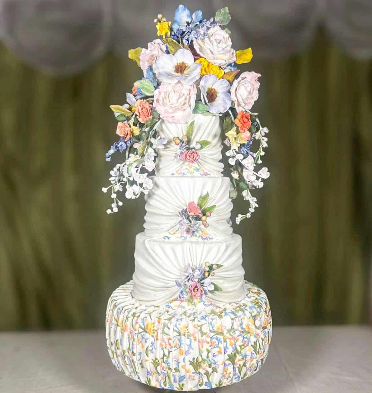 Tiered wedding cake inspired by Florentine artistry and Caterina de Medici, with Renaissance garden flowers, draped fondant, and hand-painted Florentine pattern in Florence, Italy.