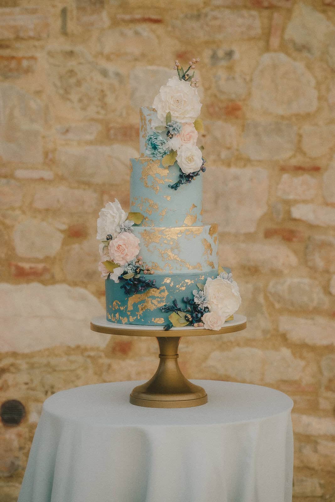 Sky-blue and midnight-blue wedding cake with 24k gold leaf and peach sugar flowers in Tuscany, Italy