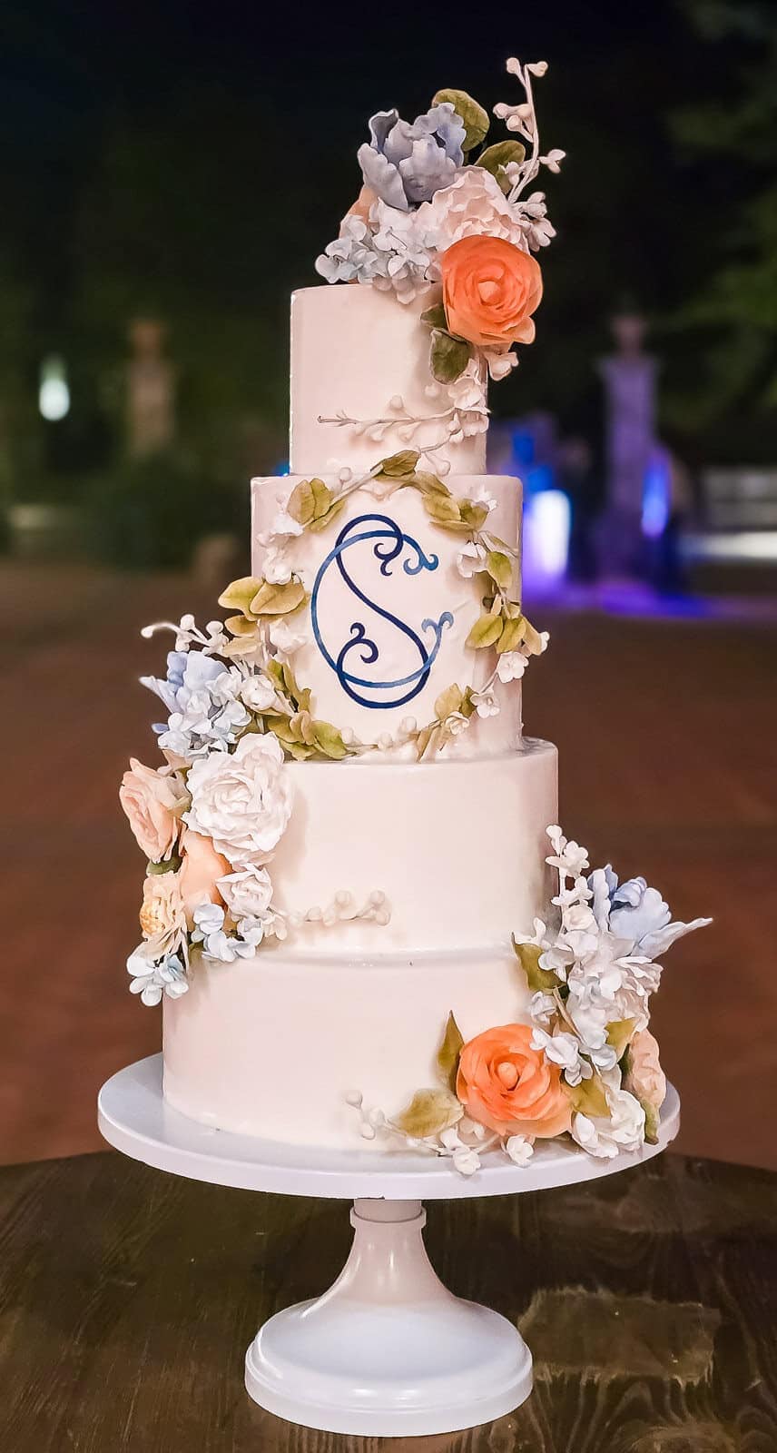 Beautiful four-tier wedding cake with floral decorations for Tuscan wedding celebrations.