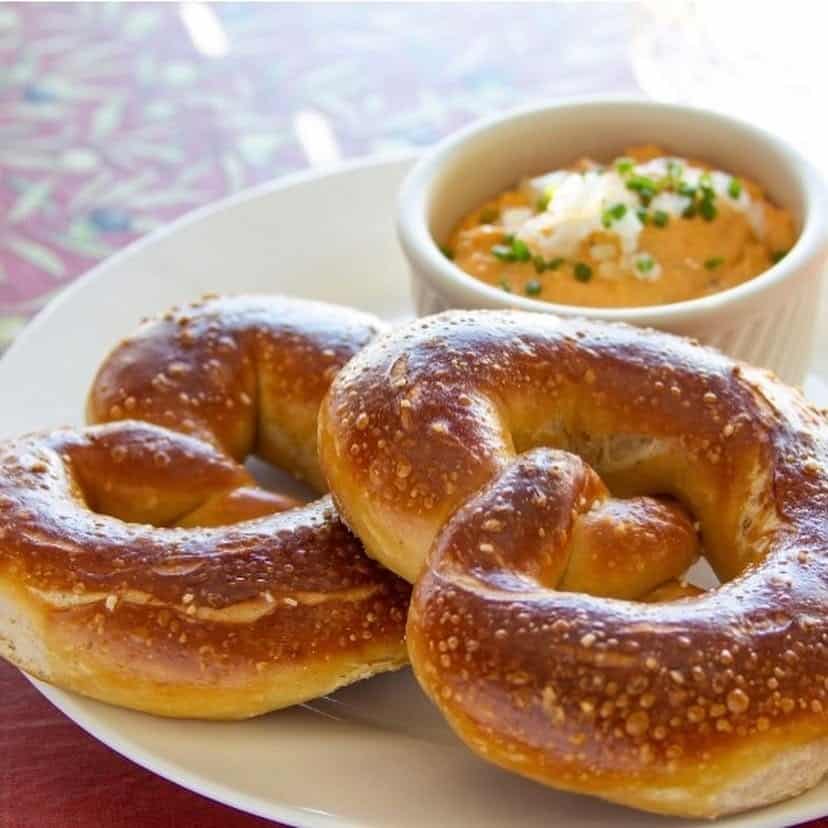 Golden-brown Bavarian pretzels with coarse salt and a side of mustard.