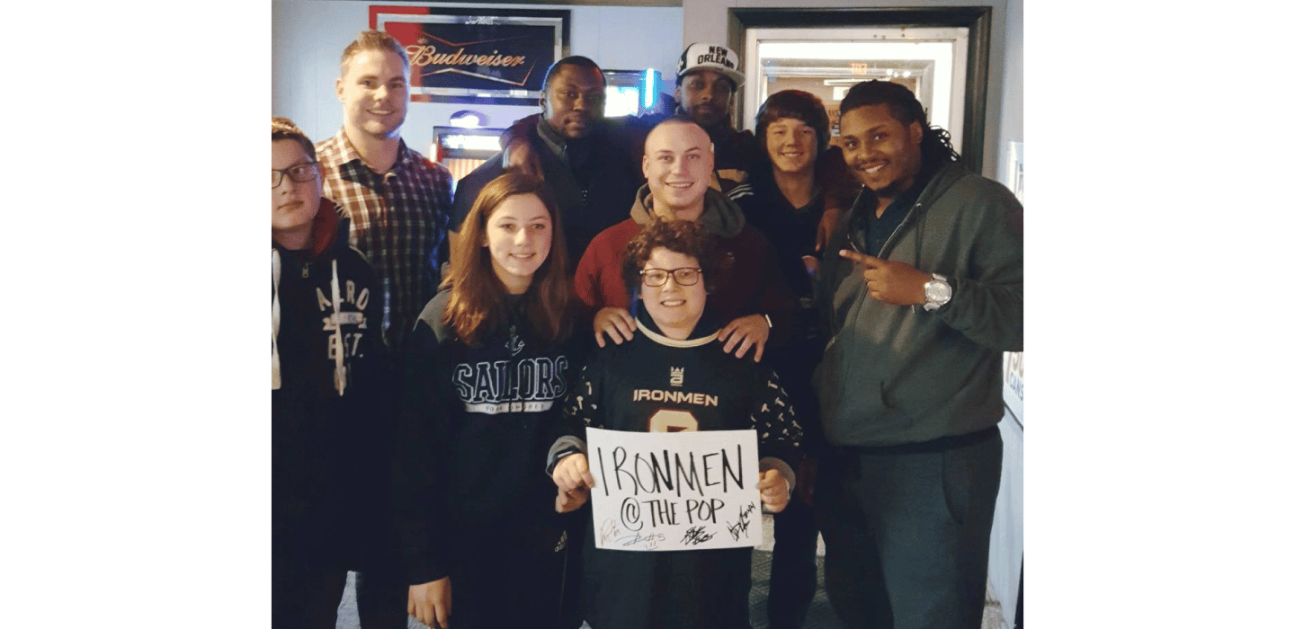 Group of West Michigan Ironmen football players and fans at a team event.