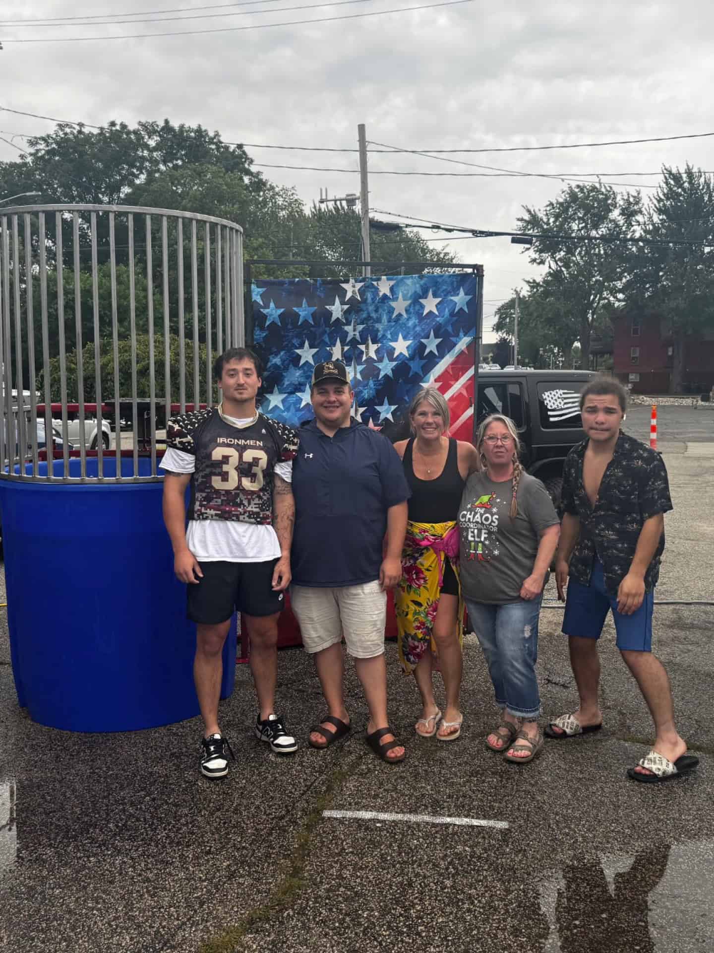 Group of fans at West Michigan Ironmen game with American flag backdrop.